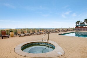 A pool area with lounge chairs and a hot tub. - All-suite condo with Gulf views, beach access, balcony, pool, spa, gym, & AC (Panama City Beach)