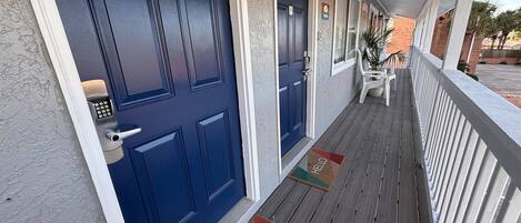 A hotel entrance with a blue door, a keypad lock, and a 'No Smoking' sign.