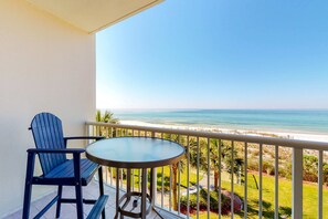 A balcony with a table and two chairs overlooking a beach. - Newly updated picturesque third-floor Gulf-front condo on Okaloosa Island (Fort Walton Beach)