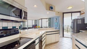 A modern kitchen with a large island, built-in appliances, and a view to the outside. - Beautiful beachside home w/central AC, internet, gulf views, shared pool/hot tub (Miramar Beach)