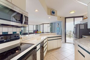A modern kitchen with a large island, built-in appliances, and a view to the outside. - Beautiful beachside home w/central AC, internet, gulf views, shared pool/hot tub (Miramar Beach)