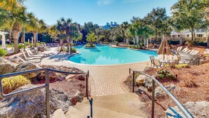 A pool area with lounge chairs and a stone pathway leading to the pool. - 3rd-floor Condo with pools, marina, tennis, large balcony, beach access (Miramar Beach)