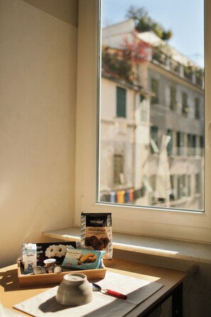 Vista per la finestra d'un edifici amb balcons i un cel serè.