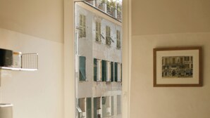 Una pequeña cocina con ventana, suelo de madera y una mesa con sillas.
