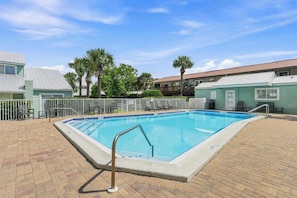 A rectangular swimming pool with a metal ladder, surrounded by a brick patio and a white fence. - Beach Condo with Free WiFi, Washer/Dryer, Beach Service Now Included (Miramar Beach)