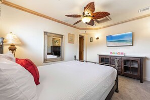 A hotel room with a bed, a ceiling fan, a television, and a cabinet. - Beach Condo with Free WiFi, Washer/Dryer, Beach Service Now Included (Miramar Beach)