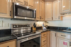 A kitchen with a stainless steel range, a microwave, and wooden cabinets. - Beach Condo with Free WiFi, Washer/Dryer, Beach Service Now Included (Miramar Beach)