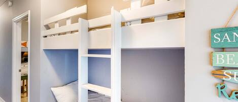 A bunk bed room with a closet and a sign on the wall.