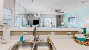 A modern kitchen with a double sink, a chandelier, and a ceiling fan. - Pet-friendly, pools, hot tub & balcony with Gulf-side calm (Destin)