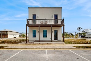 A two-story building with a balcony, large windows, and a flat roof. - Dog-friendly bay view duplex with full kitchen, washer/dryer, & central AC (Port St. Joe)