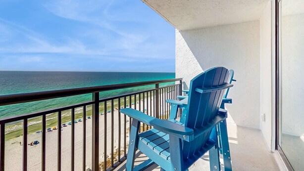 A balcony with a view of the beach and ocean.