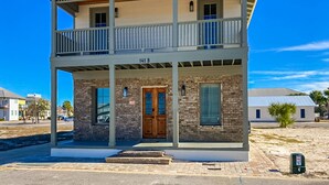 A two-story building with a balcony, a wooden door, and a brick facade. - Dog-friendly abode with a washer/dryer, central AC, & patio - perfect central location (Port St. Joe)