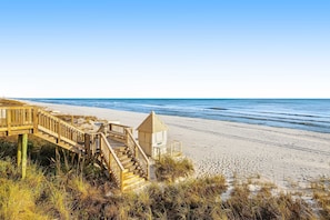 A wooden staircase leading to a beach area with a lifeguard tower. - Third-floor condo with beach access & views & outdoor pool (Miramar Beach)