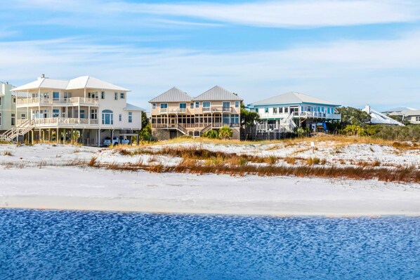 A beachfront property with multiple houses, including a large house with a balcony and a smaller house with a blue roof. - Gulf-front duplex with amazing views & screened deck - right on the beach (Santa Rosa Beach)