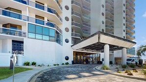 Et moderne hotel med flere etager, store vinduer og et overdækket indgangsparti.