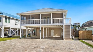 A two-story house with a covered patio and a fenced backyard. - Dog-friendly coastal getaway with private pool, patio, & grill (Port St. Joe)