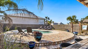 A backyard with a pool, lounge chairs, and a wooden deck. - Dog-friendly coastal getaway with private pool, patio, & grill (Port St. Joe)