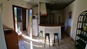 A kitchen with a refrigerator, microwave, and bar stools. - Quiet 4-person vacation rental in the countryside, with amenities just a 5-minute walk away, a pool, and more (Maubec)