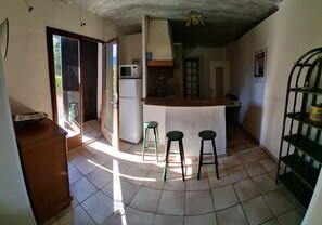 A kitchen with a refrigerator, microwave, and bar stools. - Quiet 4-person vacation rental in the countryside, with amenities just a 5-minute walk away, a pool, and more (Maubec)