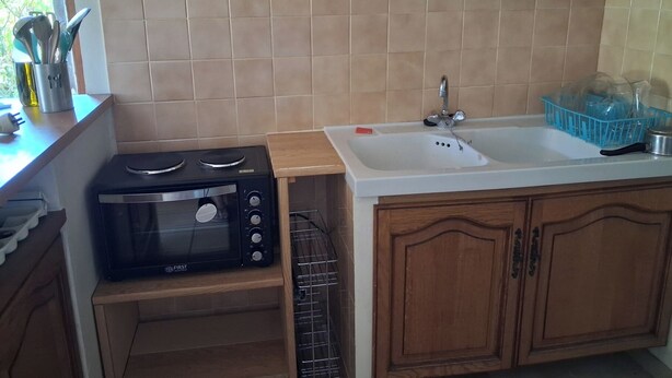 A kitchen with a built-in microwave, a sink, and wooden cabinets. - Quiet 4-person vacation rental in the countryside, with amenities just a 5-minute walk away, a pool, and more (Maubec)