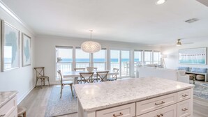 A spacious kitchen with a large island, white cabinetry, and a view of the ocean. - Gorgeous Gulf-front condo - step onto the beach from your private balcony (Santa Rosa Beach)