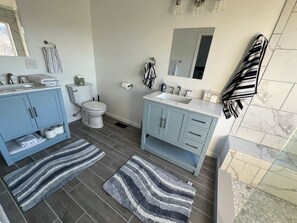 Ein Badezimmer mit zwei Waschbecken, einer Toilette und einer Duschkabine.