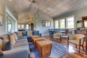 A spacious living room with a large sectional sofa, wooden side tables, and patterned chairs. - Seaside home w/ WiFi, ocean views, shared pool, & plenty of room (Inlet Beach)