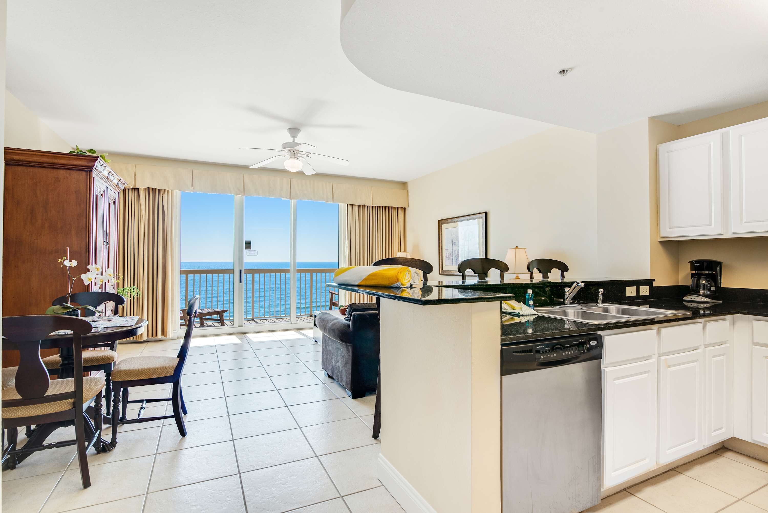 Una cocina moderna con comedor, vista al mar y ventilador de techo.