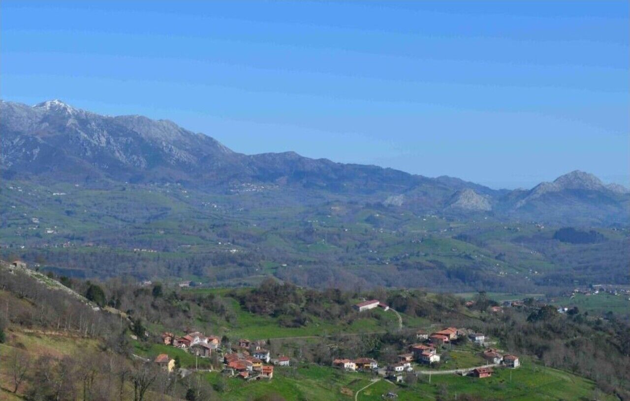 A mountainous landscape with scattered houses and a clear sky.