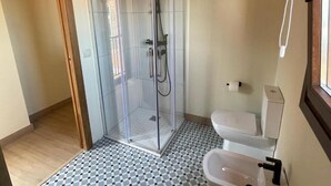 Un baño con ducha de vidrio, inodoro y bidé.