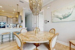 A dining area with a marble table, chairs, and a chandelier. - Luxury Prominence Gulf Escape with pool - walk to dining & shops (Rosemary Beach)