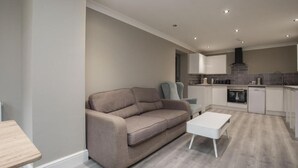 A modern kitchen with white cabinets, a grey countertop, and a built-in oven. - Charming 2-bedroom Apartment in Central Kingston Upon Thames (Kingston Upon Thames)
