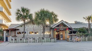 Un edificio frente a la playa con un letrero que dice "SCHOONERS LAST LOCAL BEACH CLUB".
