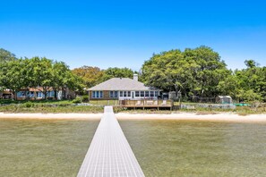 A beachfront property with a long wooden dock leading to a house with a large deck. - Sound-front beauty minutes from beach & pier with private washer&dryer & patio (Navarre)