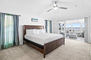A bedroom with a large bed, a ceiling fan, and a view to the outside. - Sound-front beauty minutes from beach & pier with private washer&dryer & patio (Navarre)