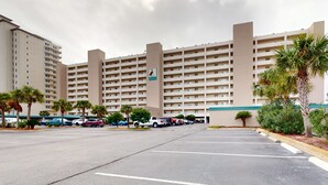 A multi-story hotel with a parking lot in front. - Waterfront Condo with Balcony, Washer/Dryer & Shared Pool (Navarre Beach)