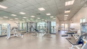 Ein Fitnessstudio mit verschiedenen Trainingsgeräten, Spiegeln und einem großen Fenster, das natürliches Licht hereinlässt.