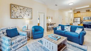 A living room with two sofas, a coffee table, and a painting on the wall. - Cozy coastal condo with shared pool,  beach access and Wifi (Santa Rosa Beach)