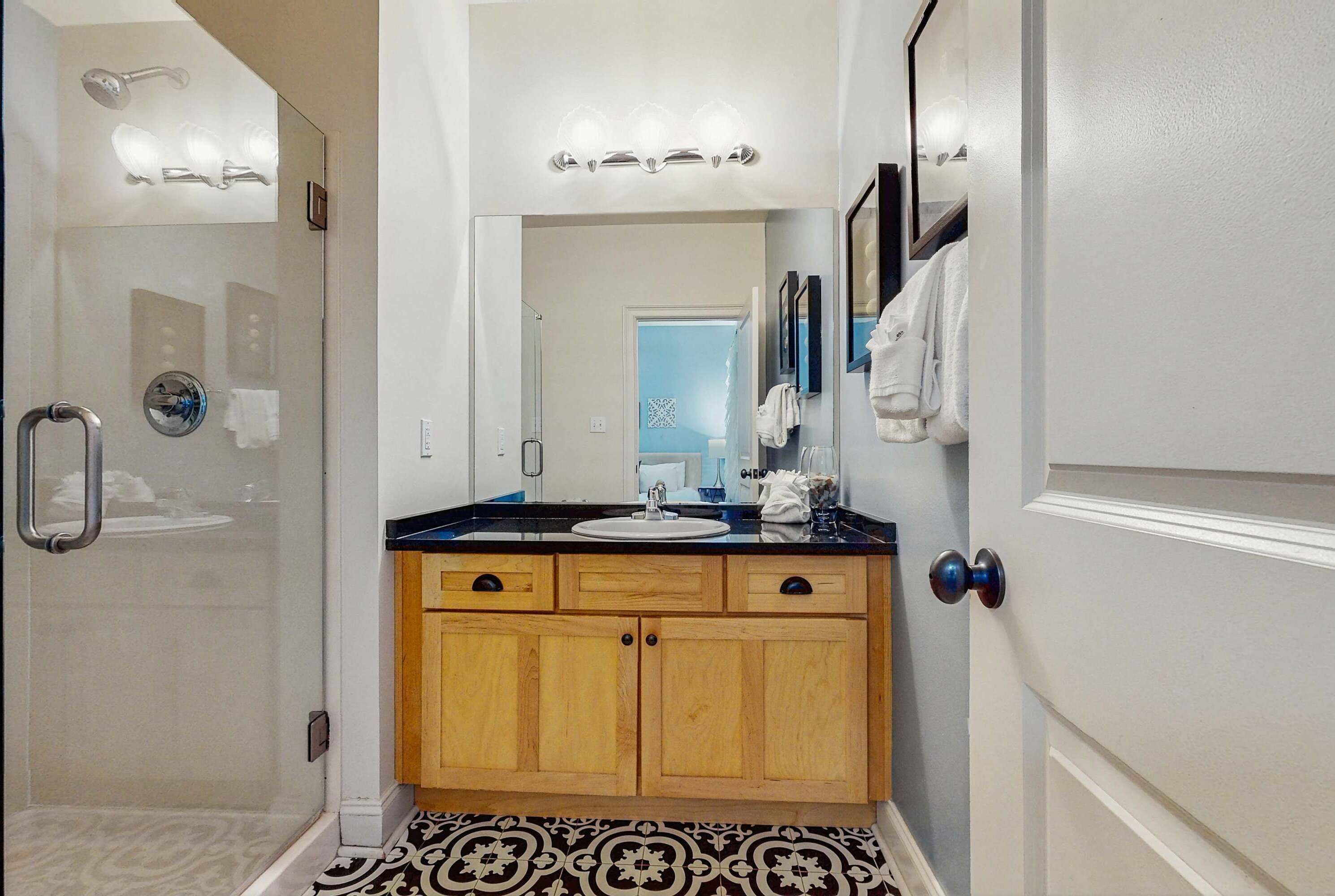 A bathroom with a shower, a sink, and a mirror.