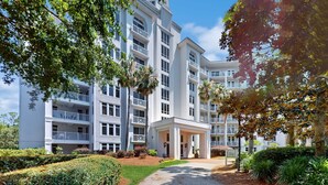 Un hôtel à plusieurs étages doté d’une cour intérieure, de balcons et d’un aménagement paysager luxuriant.