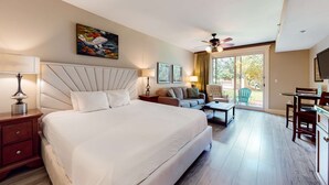 A hotel room with a large bed, a ceiling fan, a dining area, and a view of the outdoors. - LaSata beauty with patio, pools, hot tubs, fitness center, AC & beach access (Miramar Beach)
