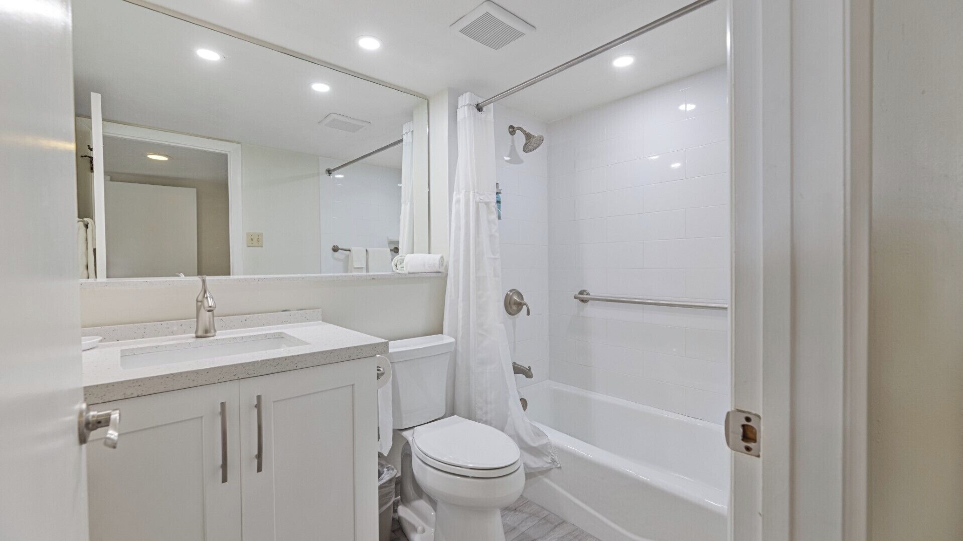Une salle de bain moderne avec un lavabo, des toilettes et une baignoire, le tout de couleur blanche.