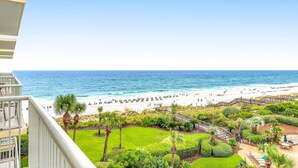Ein Strandhotel mit Blick auf den Ozean, einen Sandstrand und eine gepflegte Gartenanlage.