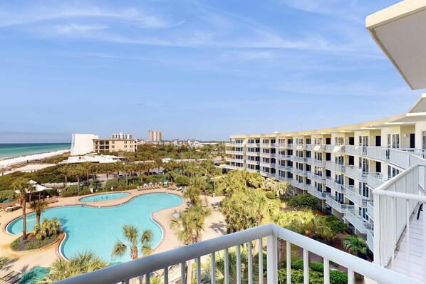 Ein Resort mit Pool, Palmen und Blick auf den Strand.
