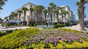 A hotel with a central courtyard featuring a flower garden and palm trees. - Beachy condo with free WiFi & shared pools, hot tub - short walk to the beach (Santa Rosa Beach)
