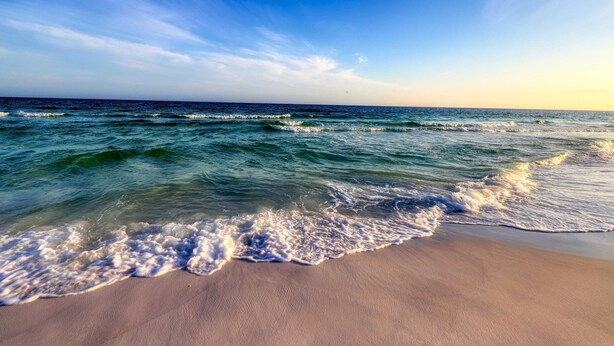 A beach with waves gently lapping onto the shore under a clear sky. - Beachy condo with free WiFi & shared pools, hot tub - short walk to the beach (Santa Rosa Beach)