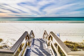 A wooden staircase leading to a beach with a clear sky. - Beautiful condo with shared pool & hot tub, private W&D - near the beach (Miramar Beach)