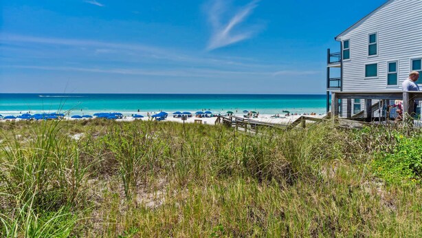 A beach house with a wooden deck and a view of the ocean. - Coastal Sandy Cay (Miramar Beach)