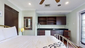 Ein Hotelzimmer mit Bett, einer kleinen Küchenzeile und einem Badezimmer.