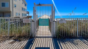A gated entrance to a beach area with signs indicating 'No tents or canopies allowed' and 'Cabins only, owners and guests only, wristbands required, no trespassing.' - Quaint Miramar Beach home with loft, pool, patio, full kitchen, & washer/dryer (Miramar Beach)
